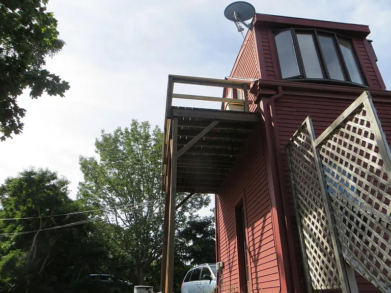 Backside, Old window with deck, driveway in front.