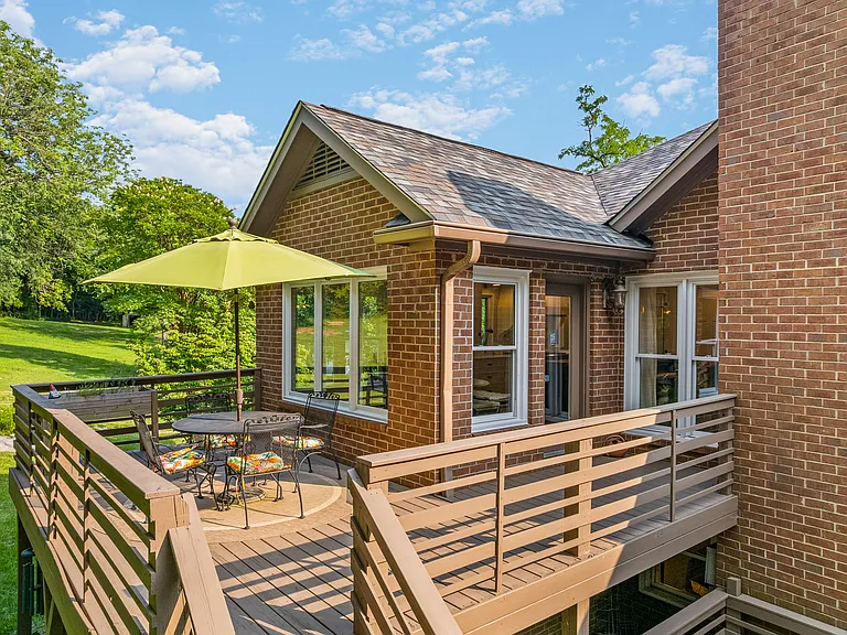 Outdoor dining table with seating for four and an umbrella on the upper patio off of the kitchen and dining areas.