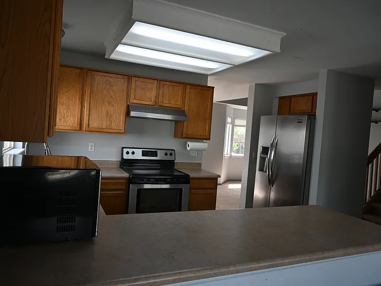Stainless steel appliances fill the kitchen.
