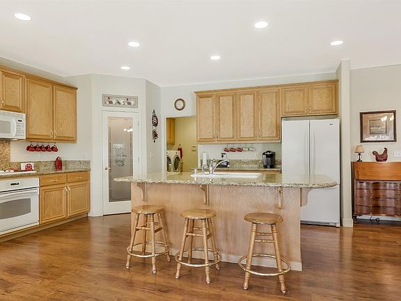 SPACIOUS kitchen with granite countertops, island with a sink, walk-in pantry, and OAK cabinets.