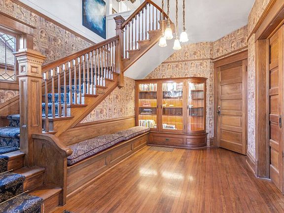 Original built-ins, gorgeous wooden banister and era wallpaper.
