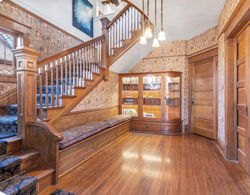 Original built-ins, gorgeous wooden banister and era wallpaper.