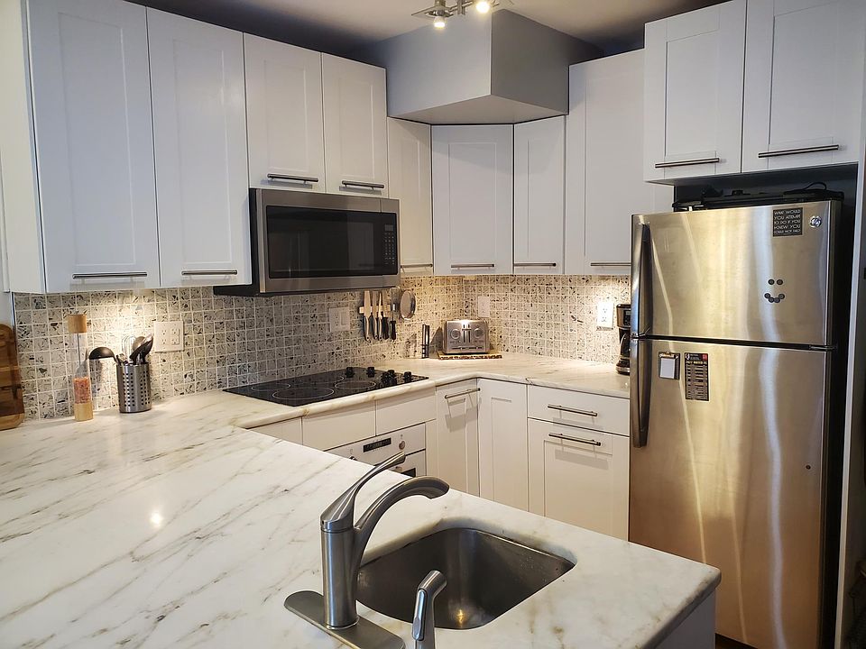 Marble countertops and stainless steel appliances in the spacious kitchen.