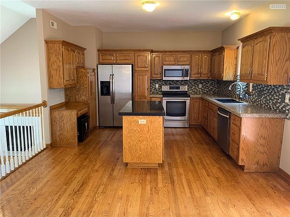 Kitchen features wood floors and stainless steel appliances