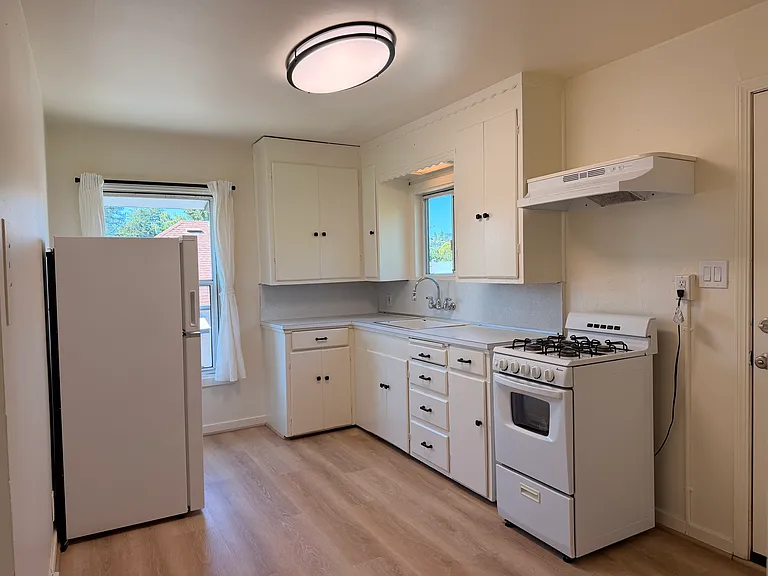 Kitchen with gas range, new ceiling light, new refrigerator and new vent hood