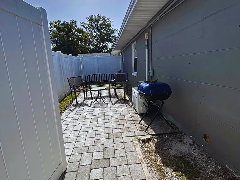 Private outdoor patio with seating and a BBQ grill.