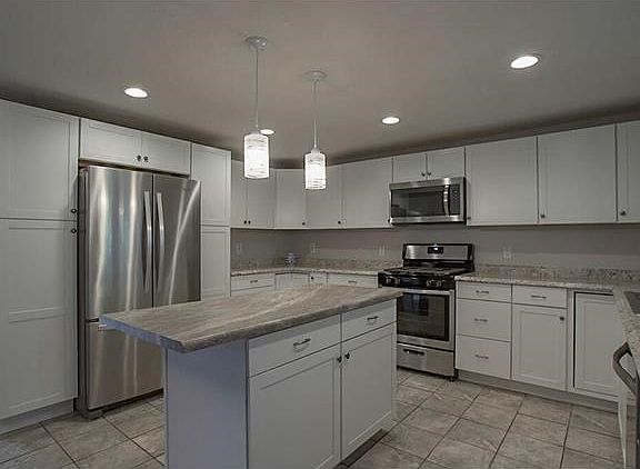 Look at this beautiful Kitchen ! New Cabinets, counter tops, Stainless Steel Appliances, Ceramic tile floor and Island.