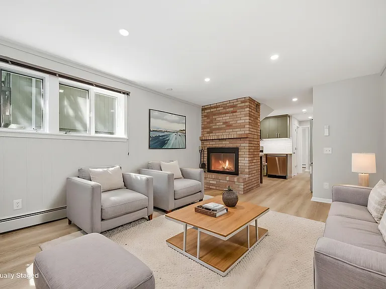 Living room with south-facing side windows and fireplace. East-facing front windows provide perfect view of morning sunrises over lake