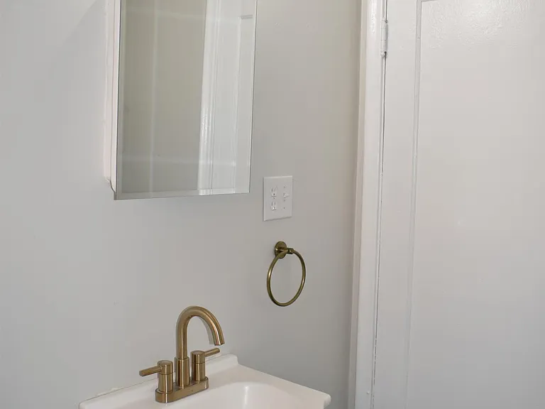 Gold sink fixtures, and new paint/flooring brighten up this space!