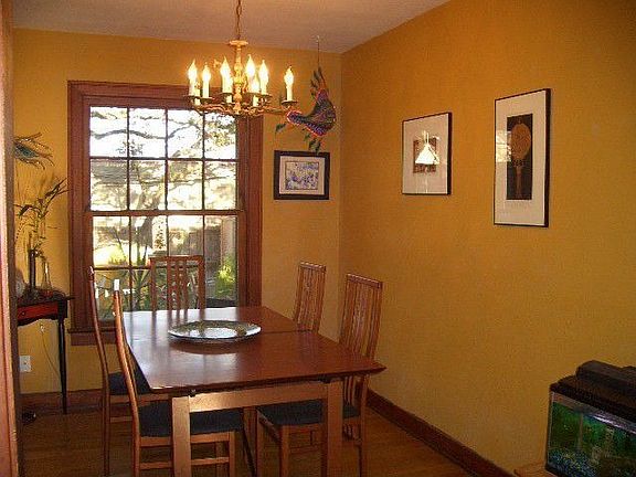 Quaint dining room with large window and wood floors
