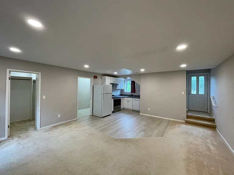 Living Room/Kitchen, Entrances to Storage and Laundry on the Left, Stair on the Right