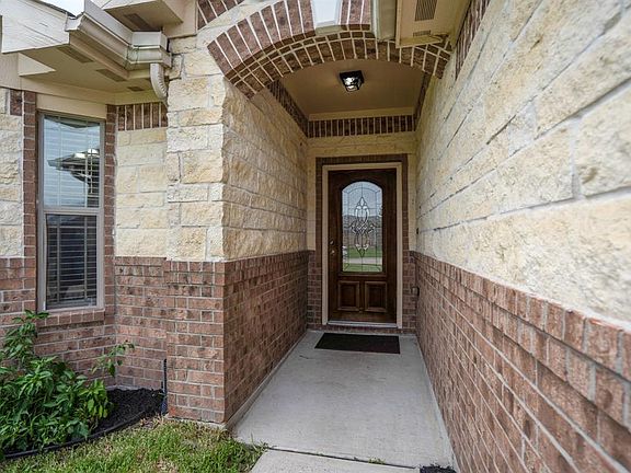 Covered front porch, with decorative glass and wood front door.