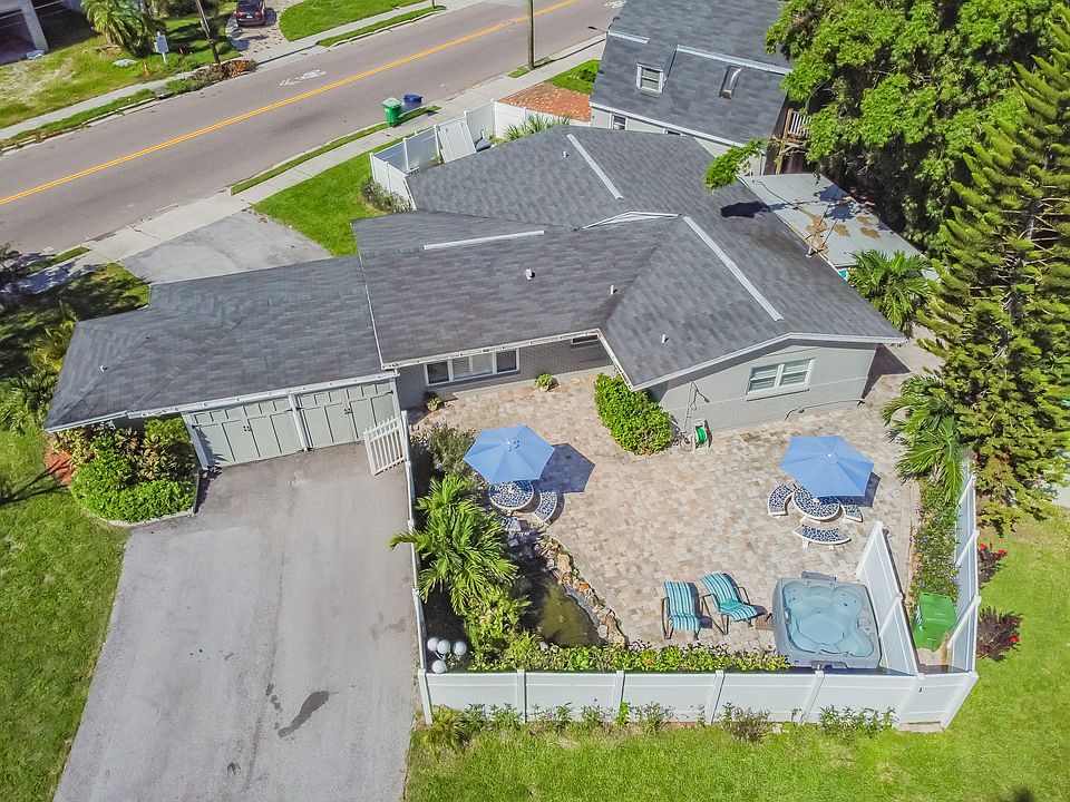 Ariel view of our private tropical backyard oasis with a new jacuzzi, choi pond, lush landscaping and outdoor shower. Offers a 2nd parking lot to accommodate 2 full - sized vehicles or 4 small vehicles.