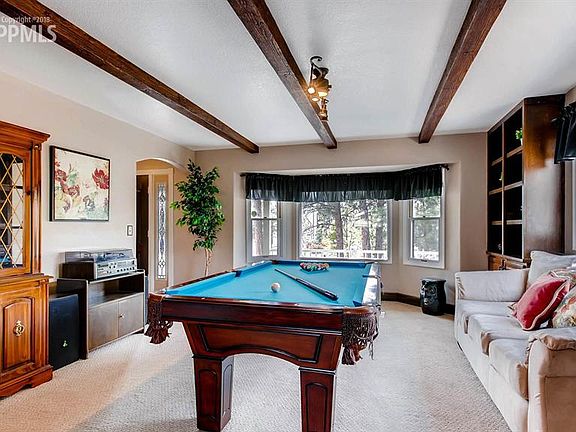 Spacious Living Room with natural light, wood beams and built in shelves!