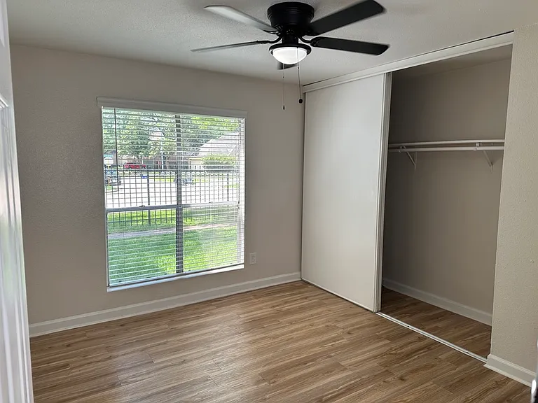 Bright and airy bedroom with sleek wooden floors, large window, and spacious closet, perfect for comfortable living. Bright and airy bedroom with sleek wooden floors, large window, and spacious closet, perfect for comfortable living.