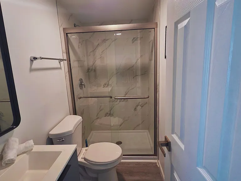 Spacious shower with bath mat and towel racks provided