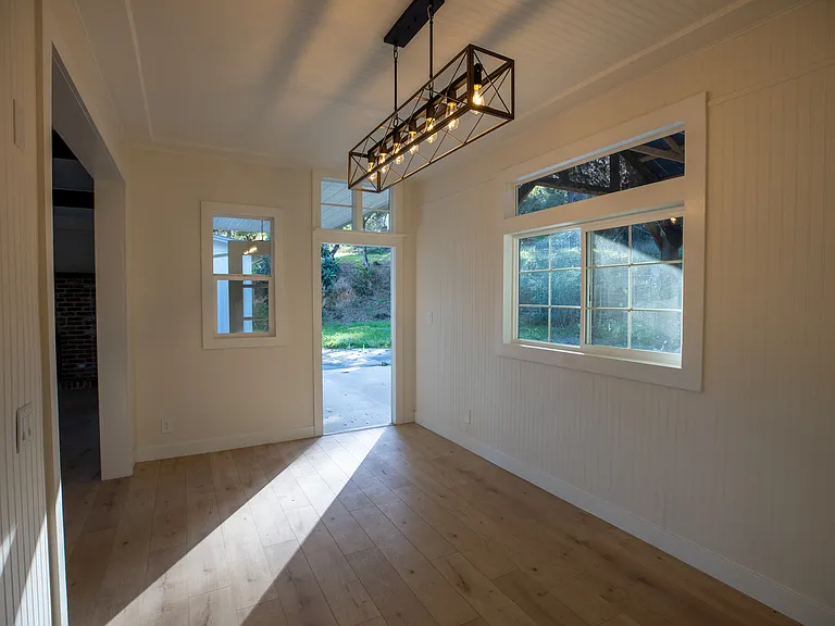 Open door leads to expansive back patio which includes covered space for an outdoor dinner party. Absolutely private.