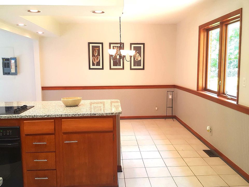 Open kitchen / dining area with wainscoting, large windows