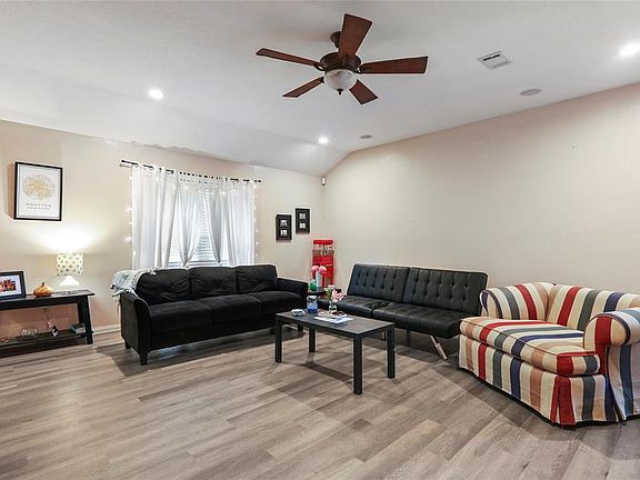Open living area with a cheery window and ceiling fan.
