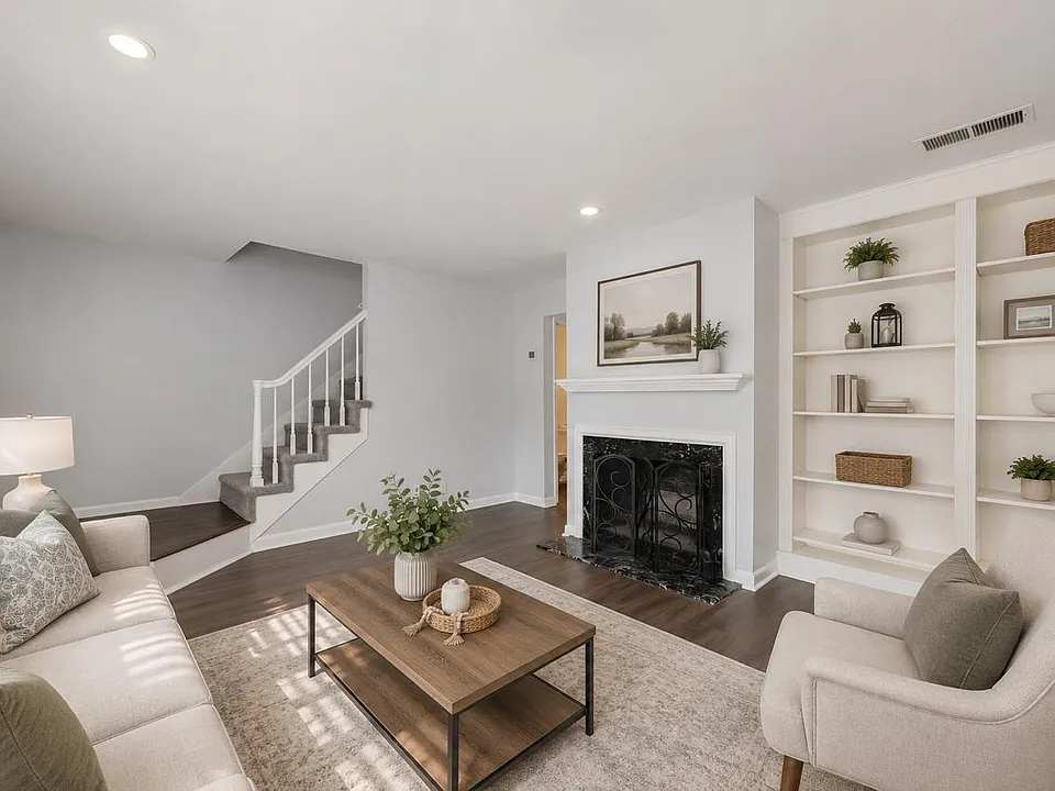 Spacious living area with fireplace, built-in shelving, and comfortable space for everyday living and entertaining. Photos are virtually staged.