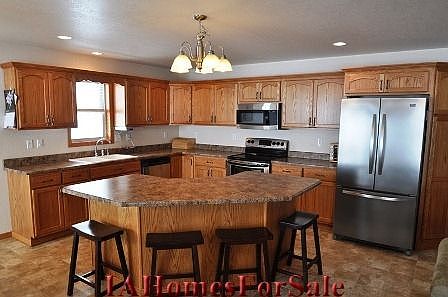 Kitchen - stainless steel appliances and breakfast bar seating for four
