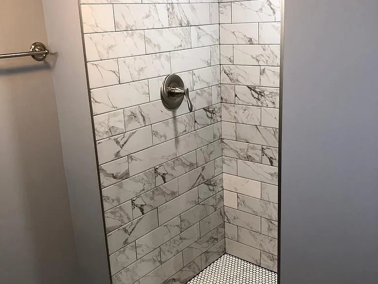 Newly enlarged and tiled shower and faucet