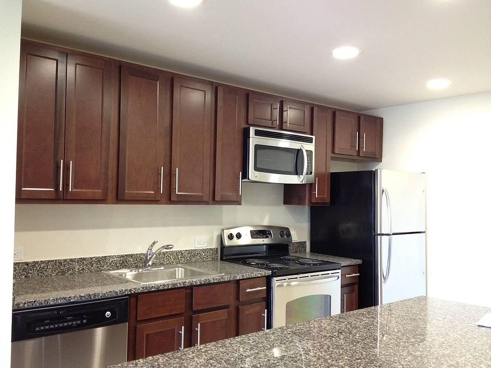 Open gourmet kitchen with custom cabinetry, large kitchen island, granite countertops and porcelain floor tiles. Top tier stainless GE Energy Star appliance suite.