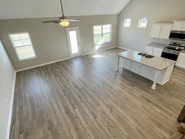 view from stairs of open concept kitchen/dining and living room