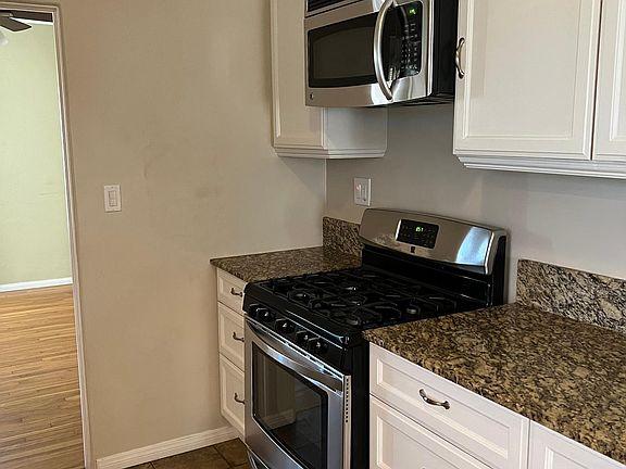 Kitchen photo with ample cabinet space. Gas cooking and over the range microwave.
