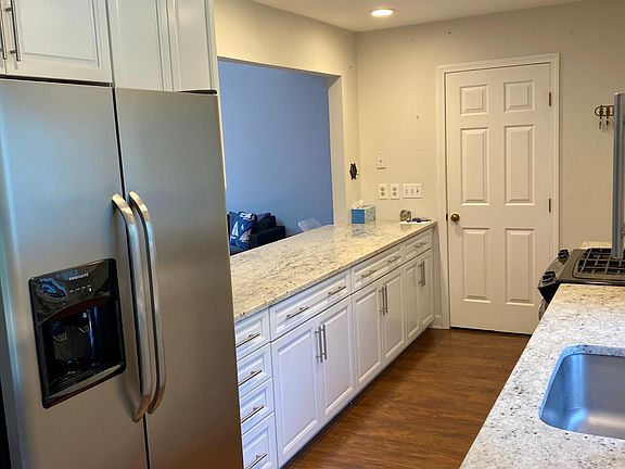 White and Granite kitchen with stainless steel, pantry and gas range