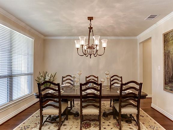 Formal dining with grand chandelier overlooks your covered front porch.