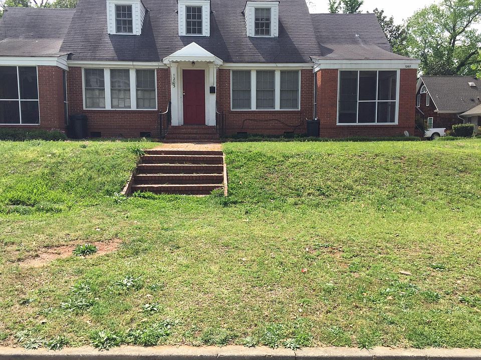 TRI-PLEX BRICK HOME RED DOOR IS ENTRANCE TO UPSTAIRS
