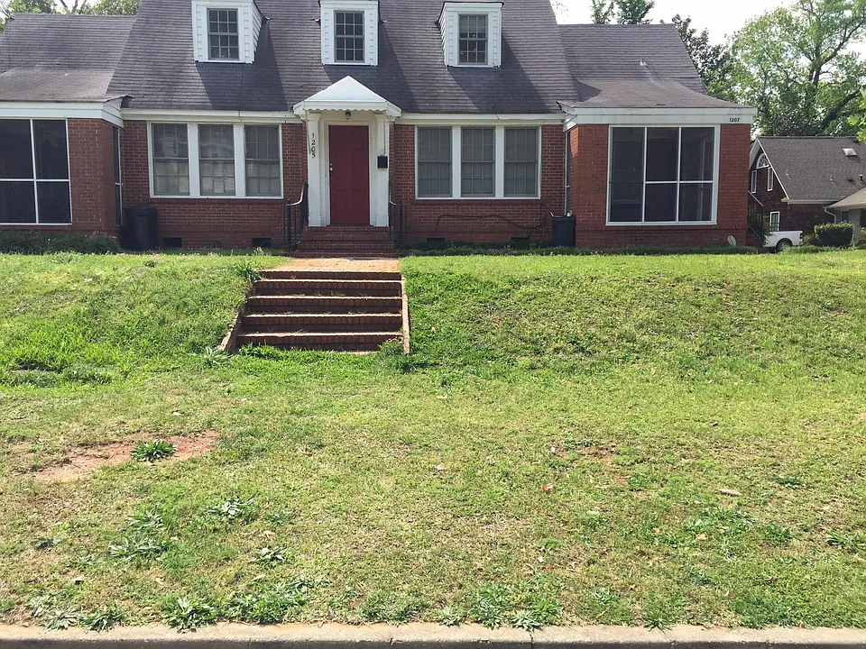 TRI-PLEX BRICK HOME RED DOOR IS ENTRANCE TO UPSTAIRS