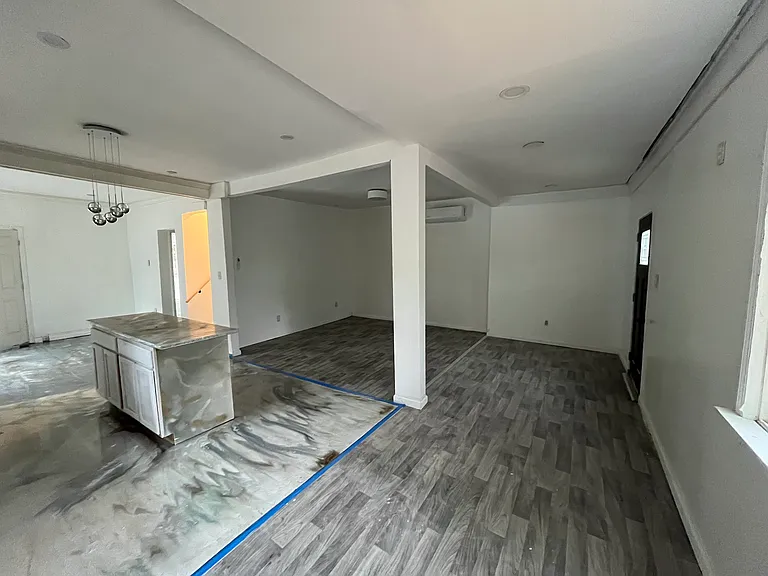 Open concept view of kitchen & living room front door towards right