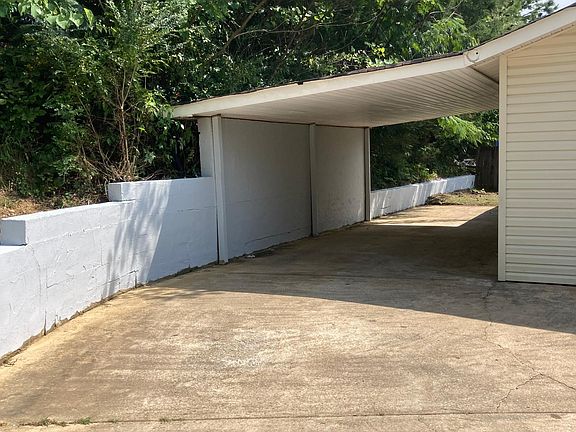 Carport and small yard area. Door leads into kitchen from carport.
