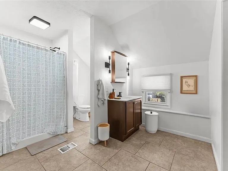 En suite primary bathroom with connected in-unit laundry and walk-in closet