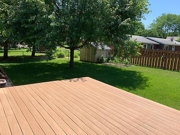 Deck and shaded backyard with garden space
