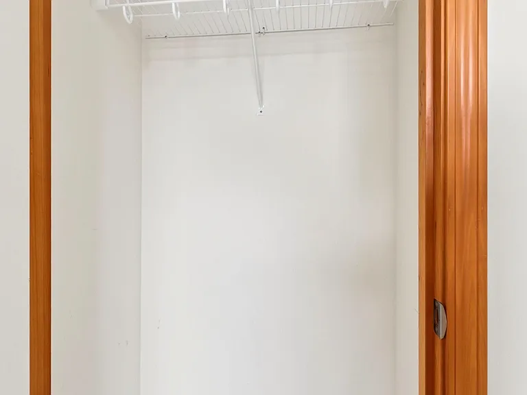 Dedicated closet with sturdy wire shelving and hanging space for streamlined clothing and accessory storage.