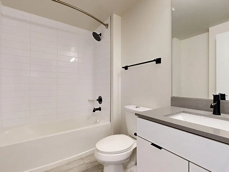 Apartment Bathroom with large soaking tub, vanity mirror and Wood-Style Flooring.