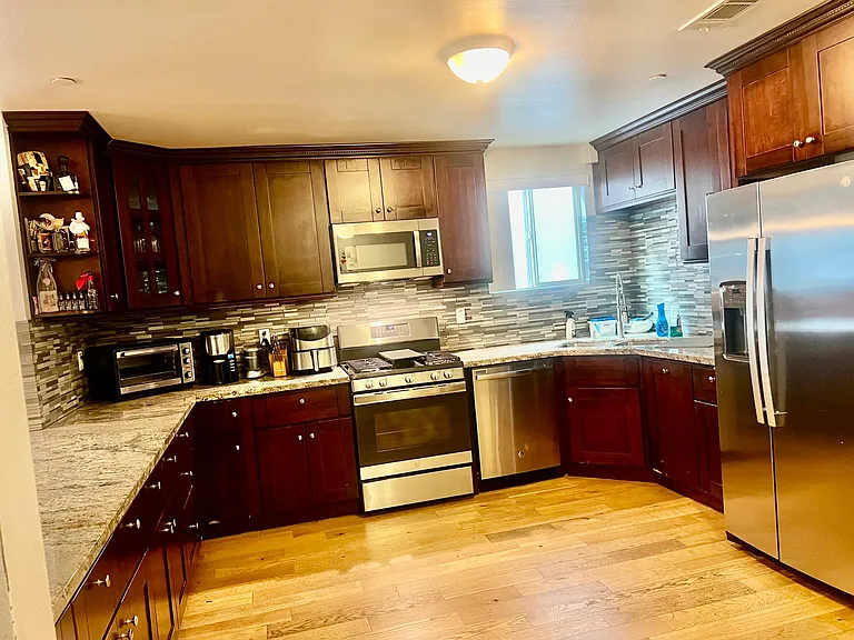 Full Kitchen w/ stainless steel appliances including Air Fryer Oven, Dishwasher, Refrigerator w/ Ice maker and built-in Microwave. Marble counter tops, Dark wood cabinets, Bamboo hardwood floors through out the Home. Kitchen has cooking essentials.
