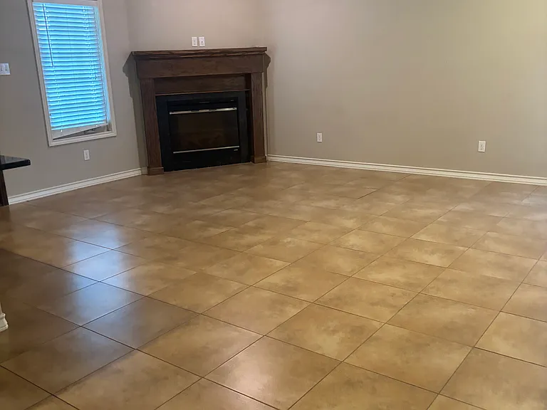 Living room with wood blinds low maintenance flooring and corner fireplace