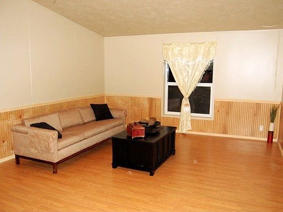 Spacious family room off the kitchen with wood laminate floors and vaulted ceilings.