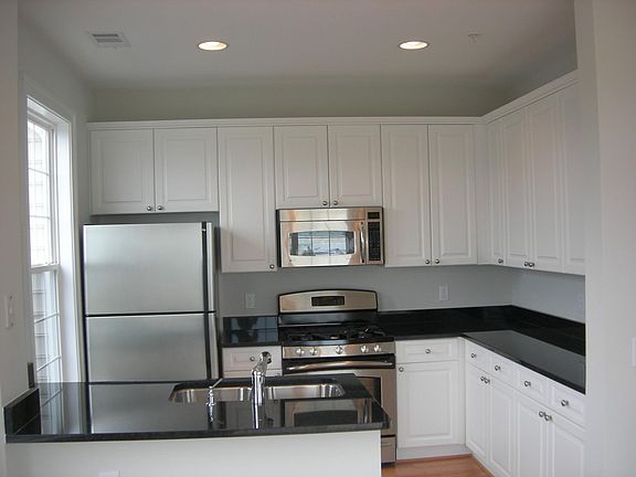 Kitchen with granite, white cabinet and stainless steel appliances.