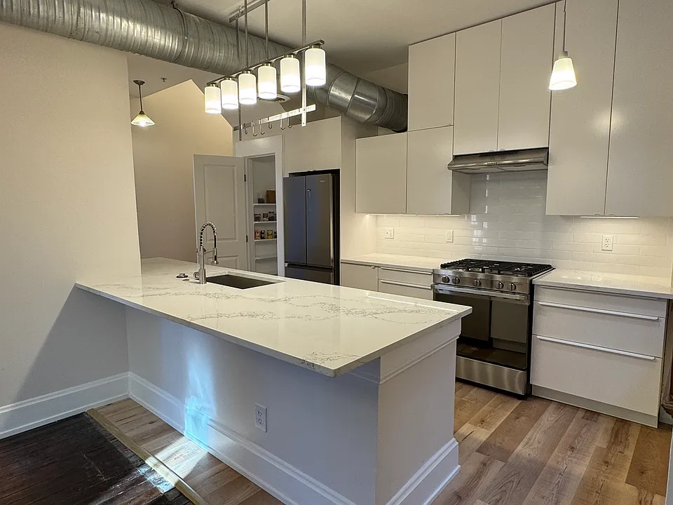Floor to ceiling cabinetry with quartz countertops, deep sink, top of the line appliances and separate pantry