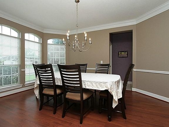 The formal dining has laminate wood floors and a wall of windows for wonderful lighting.