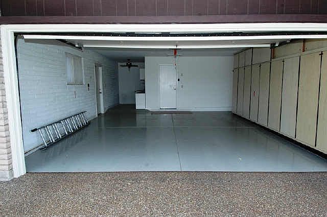 Very clean garage has lots of cabinets and room for workshop or golf cart