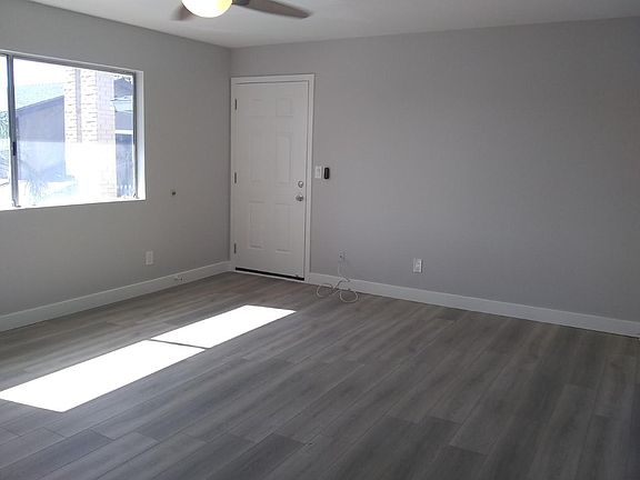 Large living room with large, new ceiling fan. New front door and security door