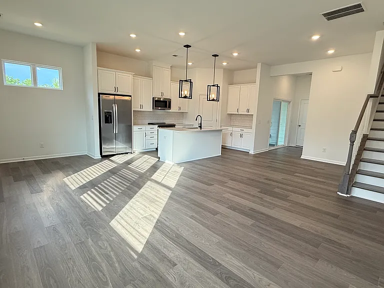 Open-concept layout featuring a gourmet kitchen, spacious living area, and elegant staircase.