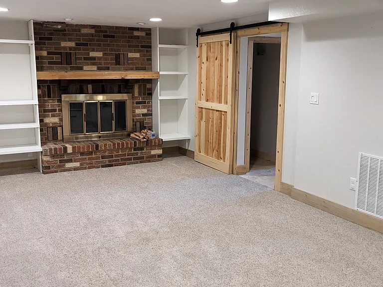 Basement with Fireplace, Built in Cabinetry . Barn Door to 5-Piece Spa Bathroom