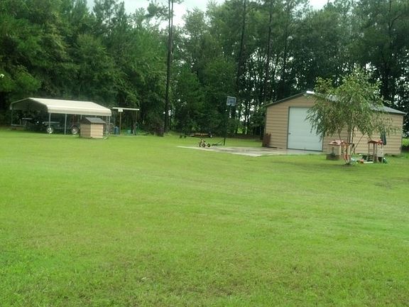NICE SHOP W/BASKETBALL COURT OUT FRONT : PLENTY OF STORAGE, SHOP IS 24X25, DOUBLE CARPORT & SHELTER 